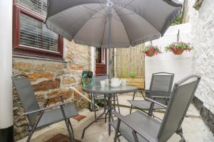 a table and chairs with an umbrella on a patio at Walter in Penzance
