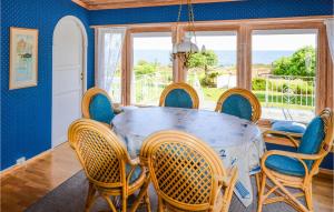 a dining room with a table and chairs at Beach Front Home In Frvik With House Sea View in Arendal
