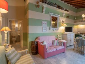 sala de estar con silla rosa y TV en Surrounded by the beautiful sloping Tuscan landscape, en Casole dʼElsa
