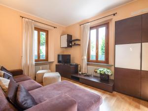 a living room with a couch and a flat screen tv at Modern Apartment in Meina near the lake in Meina