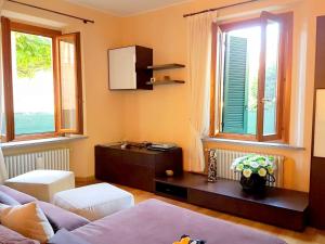 un soggiorno con divano e 2 finestre di Modern Apartment in Meina near the lake a Meina