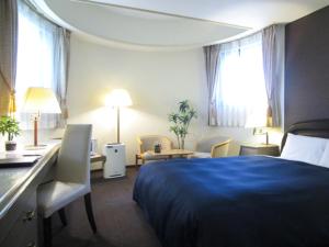 札幌市にあるホテルリブマックスBUDGET札幌のベッドとデスクが備わるホテルルームです。