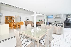 a dining room and living room with a table and chairs at Elegant, Stylish, Magical Coolum Beach House - ZA8 in Coolum Beach