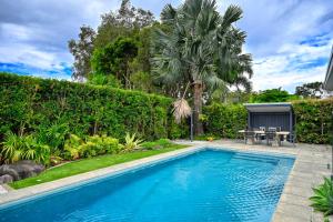 a swimming pool in a yard with a table at Elegant, Stylish, Magical Coolum Beach House - ZA8 in Coolum Beach