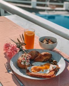 a plate of breakfast food on a table with a drink at Hotel Petradi in Ios Chora