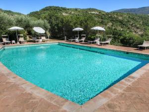 アッシジにあるPicturesque Holiday Home in Assisi with Poolのスイミングプール(椅子、パラソル付)