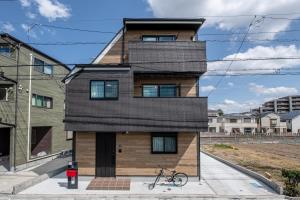 una casa con techo negro en Ici Japon Village en Tokio