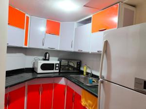 a kitchen with red and white cabinets and a microwave at جولف بورتو مارينا in El Alamein