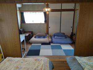 石巻市にある民家の一室2 Private Room in Japanese Vintage House with 2 Beds, Free Parking Good to Travel for Tashiro Cats Islandのベッド2台と窓が備わる小さな客室です。