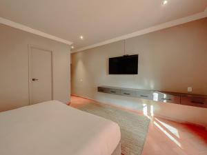 a bedroom with a bed and a flat screen tv at Mikaella Hotel in San Miguel de Allende