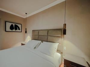 a bedroom with a bed with white sheets and pillows at Mikaella Hotel in San Miguel de Allende