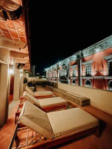 a row of beds on a rooftop at night at Mikaella Hotel in San Miguel de Allende