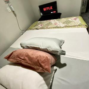 ein Bett mit zwei Kissen darüber und einem m2 in der Unterkunft Flat Aeroporto vitoria in Vitória