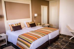 a bedroom with a large bed with a striped blanket at Agro-Turismo do ROXO in Santa Vitória