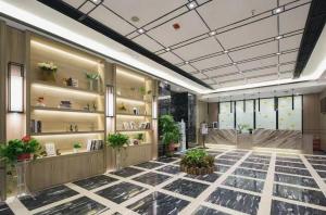 un vestíbulo con plantas y estanterías en un edificio en Morninginn, Meixi Lake West Bus Station en Changsha