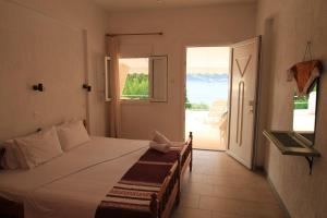 a bedroom with a bed and a door to a patio at Maeiz Skopelos in Skopelos Town
