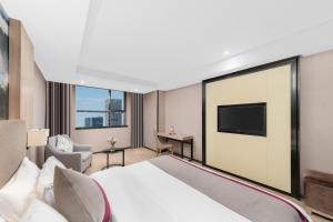 a hotel room with a bed and a flat screen tv at Morninginn, Meixi Lake West Bus Station in Changsha