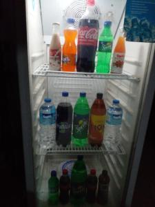 an open refrigerator filled with bottles of soda and drinks at Muthu Villa Sri Lanka in Kalutara