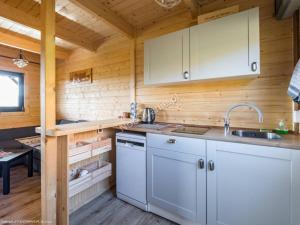 a kitchen with white appliances in a wooden cabin at Domek Pod Groniem in Jasnowice