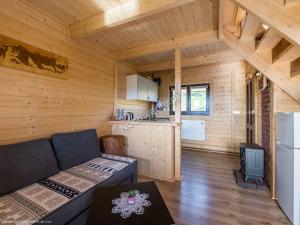 a living room with a couch and a kitchen at Domek Pod Groniem in Jasnowice