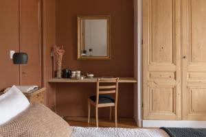 a bedroom with a desk with a chair and a mirror at La Maison des Monts d'Or in Saint-Germain-au-Mont-dʼOr