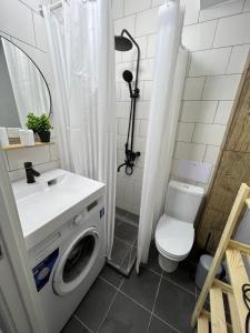 a bathroom with a washing machine and a toilet at Стильная студия Shadow Атакент in Almaty