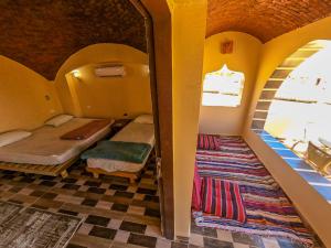 a small room with two beds and a window at Flight Mode Camp in Nuweiba