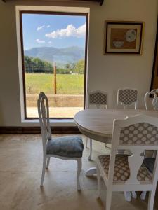 ein Esszimmer mit einem Tisch, Stühlen und einem Fenster in der Unterkunft El Bosque de Candeleda in Candeleda