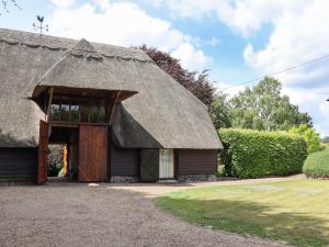 a house with a thatched roof with a doorway at Blackbird Cottage in Canterbury