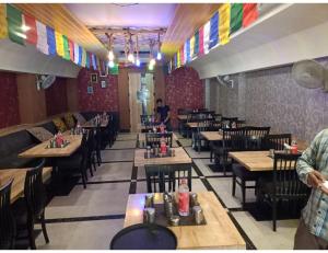 um restaurante com mesas e cadeiras de madeira numa sala em Hotel Abhinandan, Paonta Sahib em Pāonta Sāhib