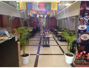 um restaurante com piso em azulejo com vasos de plantas em Hotel Abhinandan, Paonta Sahib em Pāonta Sāhib