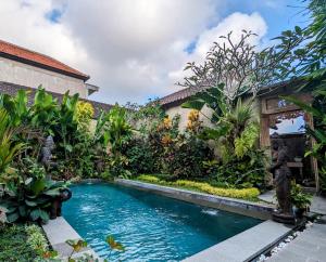 uma piscina no meio de um jardim em Villa Ulun Mertha - 1BR Private Villa em Ubud