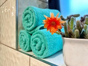 a flower in a vase next to towels and a plant at JUNÁK ubytování v soukromí in Vranov nad Dyjí