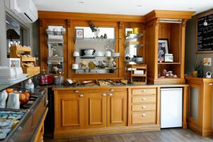 a kitchen with wooden cabinets and shelves with dishes at Fasthotel Reims-Taissy in Reims
