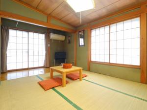 a room with a table and two large windows at サンバレーひぐち in Muikamachi