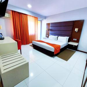 a hotel room with a bed and a red curtain at Hotel Embaixador in Beira