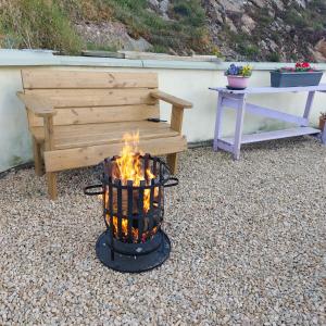 a fire pit in front of a bench at Tobar Na Si Apartments in Letterkenny