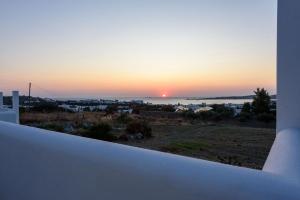 einen Sonnenuntergang vom Balkon eines Hauses aus gesehen in der Unterkunft Aigaiou Avra Apartments in Parikia