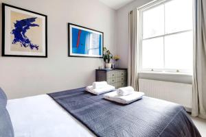 a bedroom with a bed with two towels on it at Contemporary Clapham Living in London