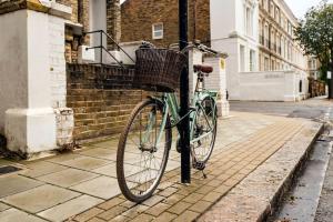 uma bicicleta está acorrentada a um poste numa rua em Contemporary Clapham Living em Londres