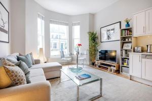 ein Wohnzimmer mit einem Sofa und einem Tisch in der Unterkunft Contemporary Clapham Living in London