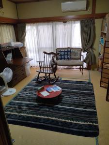 a living room with a chair and a rug at 民家の一室1 Private Room in Japanese Vintage House with Tatami, Single Bed, Free Parking, Good to Travel for Tashiro Cats Island in Ishinomaki