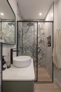 uma casa de banho com um lavatório e um chuveiro em La Maison des Monts d'Or em Saint-Germain-au-Mont-dʼOr