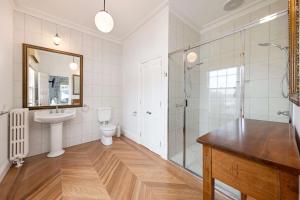 La salle de bains est pourvue d'un lavabo, d'une douche et de toilettes. dans l'établissement Oscars Waterfront Boutique Hotel, à Port Fairy