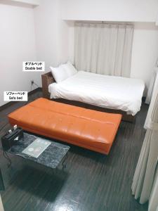 een slaapkamer met een bed en een tafel. bij COCOSTAY Matoba ココステイ マトバ in Hiroshima
