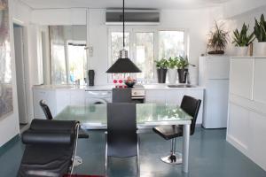 een keuken met een glazen tafel en zwarte stoelen bij Modern, fully equipped apt with private balcony - CT1 in Athene