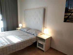 デルテブレにあるMi Apartamento en el Delta del Ebro+のベッドルーム1室(ベッド1台付)、2泊分のスタンド(ランプ付)