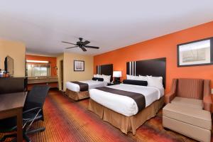 ein Hotelzimmer mit 2 Betten und einem Schreibtisch in der Unterkunft Best Western Inn in Monroeville