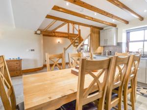 a kitchen and dining room with a wooden table and chairs at Orcaber Farmhouse in Lancaster