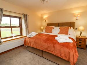 a bedroom with a large bed and a window at Orcaber Farmhouse in Lancaster